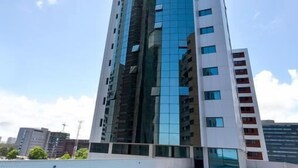 A modern high-rise building with a rooftop swimming pool. - Betel Beach Flat (Recife)