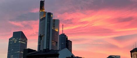 A city skyline with modern buildings and a sunset sky.