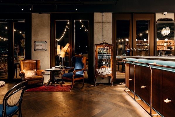 A bar area with wooden furniture, a red rug, and string lights.