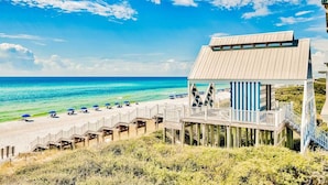 A beachside building with a wooden deck and a view of the ocean. - Gulf Front in the Middle of Seaside! Elevator, Community Pools, Bikes, and More (Santa Rosa Beach)