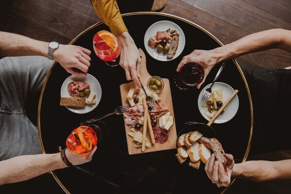 A round table with various food items and drinks, surrounded by people.