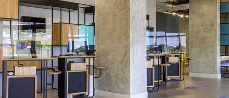 A modern office space with desks, chairs, and large windows.
