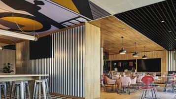 A modern restaurant interior with a checkered floor, bar area with stools, and dining tables with chairs.