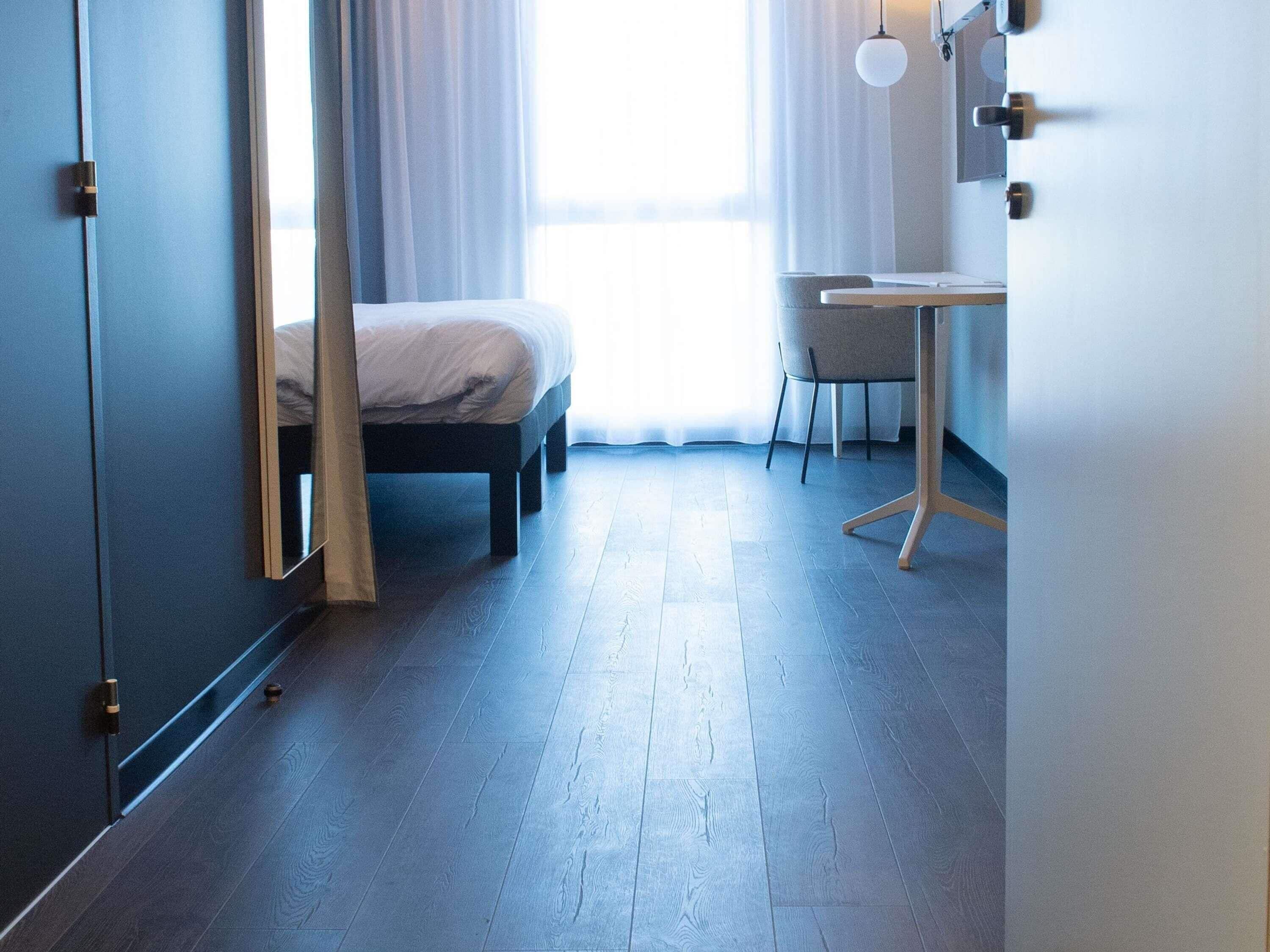 Une chambre avec un lit, un bureau et une chaise.