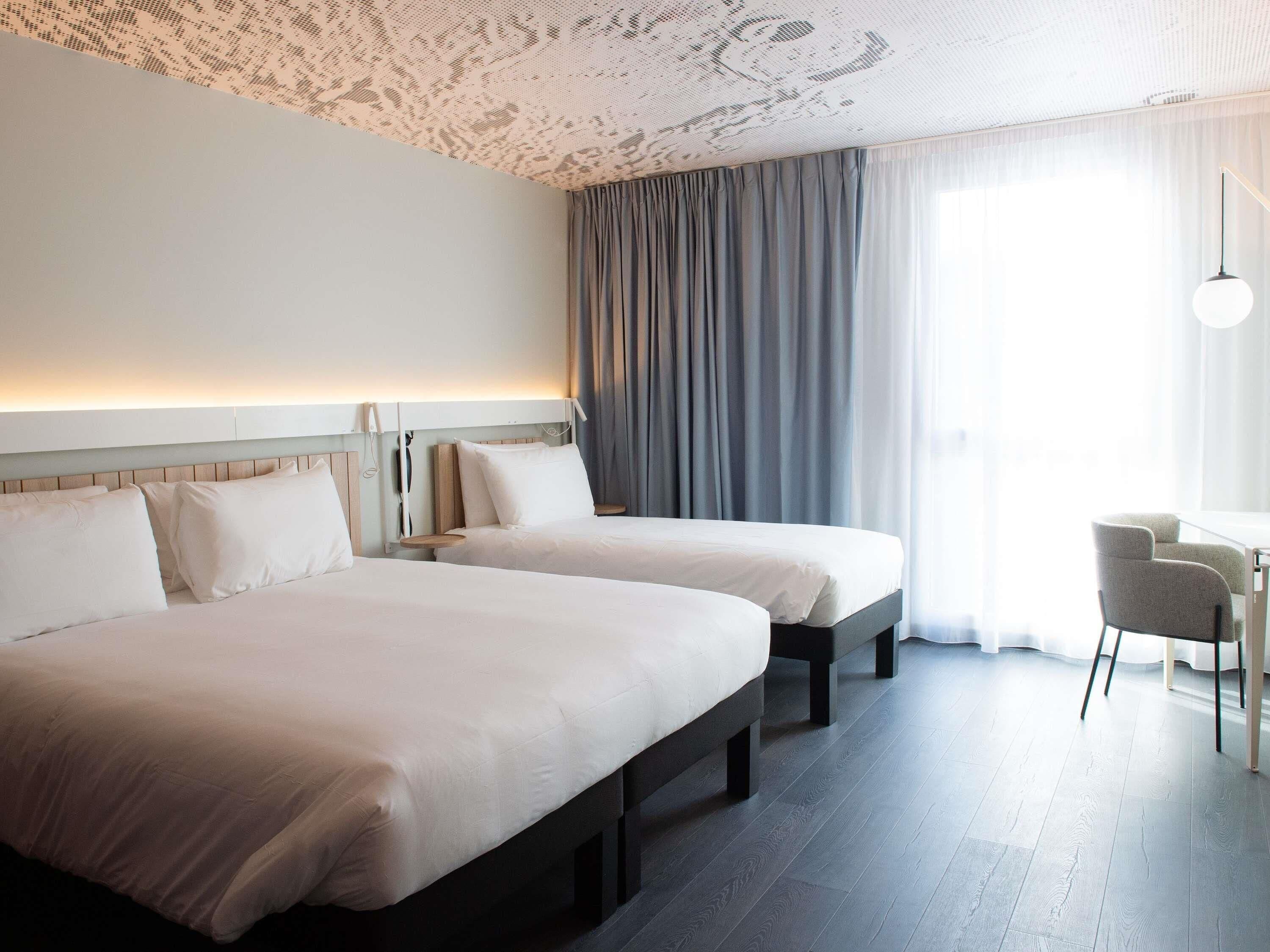Una habitación de hotel con dos camas, un escritorio y una silla.