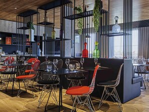 Ein modernes Restaurant mit schwarzen Metallstühlen, Tischen und einer schwarzen Bar.