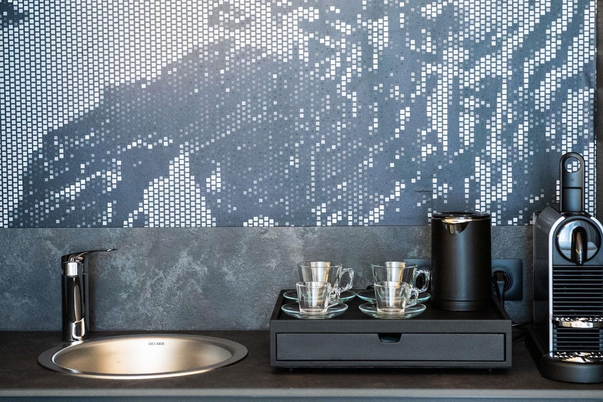 Eine moderne Küche mit digitalem Rückwand, einer Kaffeemaschine und einem Spülbecken.