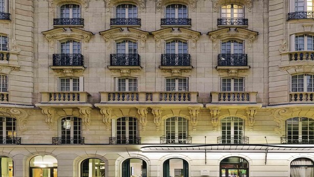 Un edificio de varios pisos con balcones ornamentados y ventanas amplias.