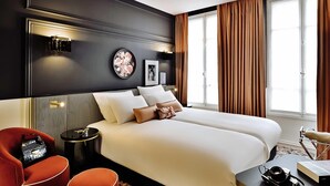 Una habitación de hotel con una cama grande, una mesita de noche, una silla y una pequeña mesa redonda.