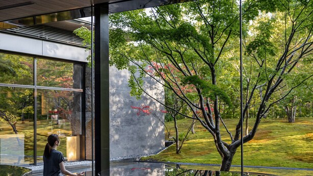 A person meditating in a modern room with large windows overlooking a garden. - Garrya Nijo Castle Kyoto (Kyoto)
