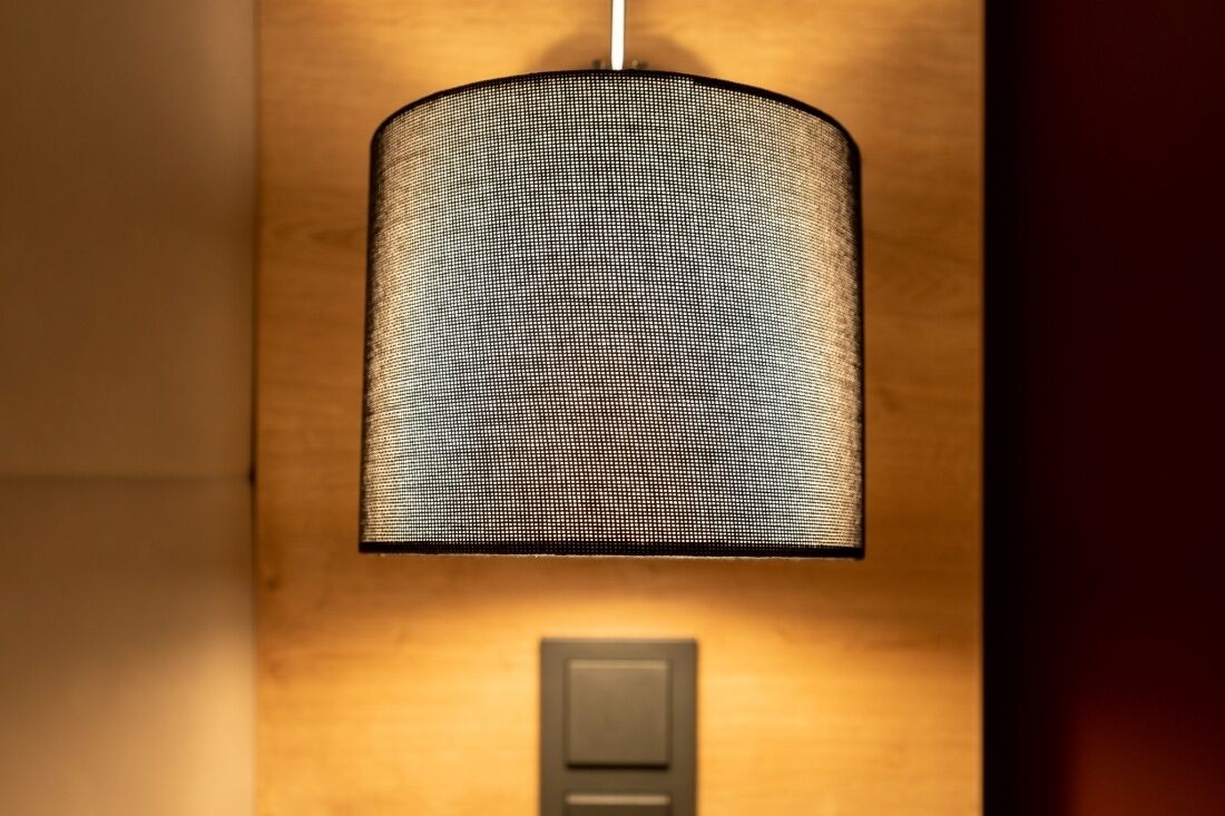 Een wandlamp met een structuurbezet kap.
