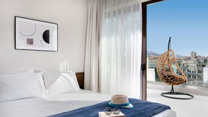 Een hotelkamer met een bed, een hangstoel, een hoed en een boek.