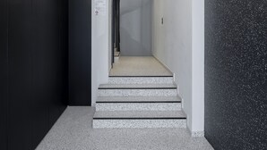 Een modern interieur met een trap, een ronde lamp en een muren met een gespetterd motief.