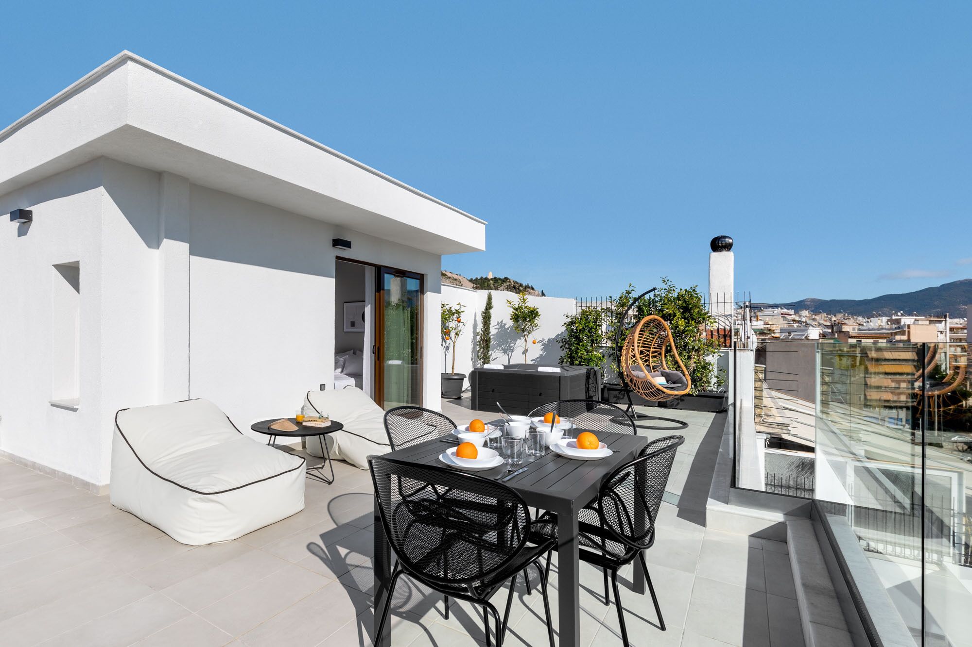 Une terrasse sur le toit équipée d’une table à manger, de chaises et d’un jacuzzi.