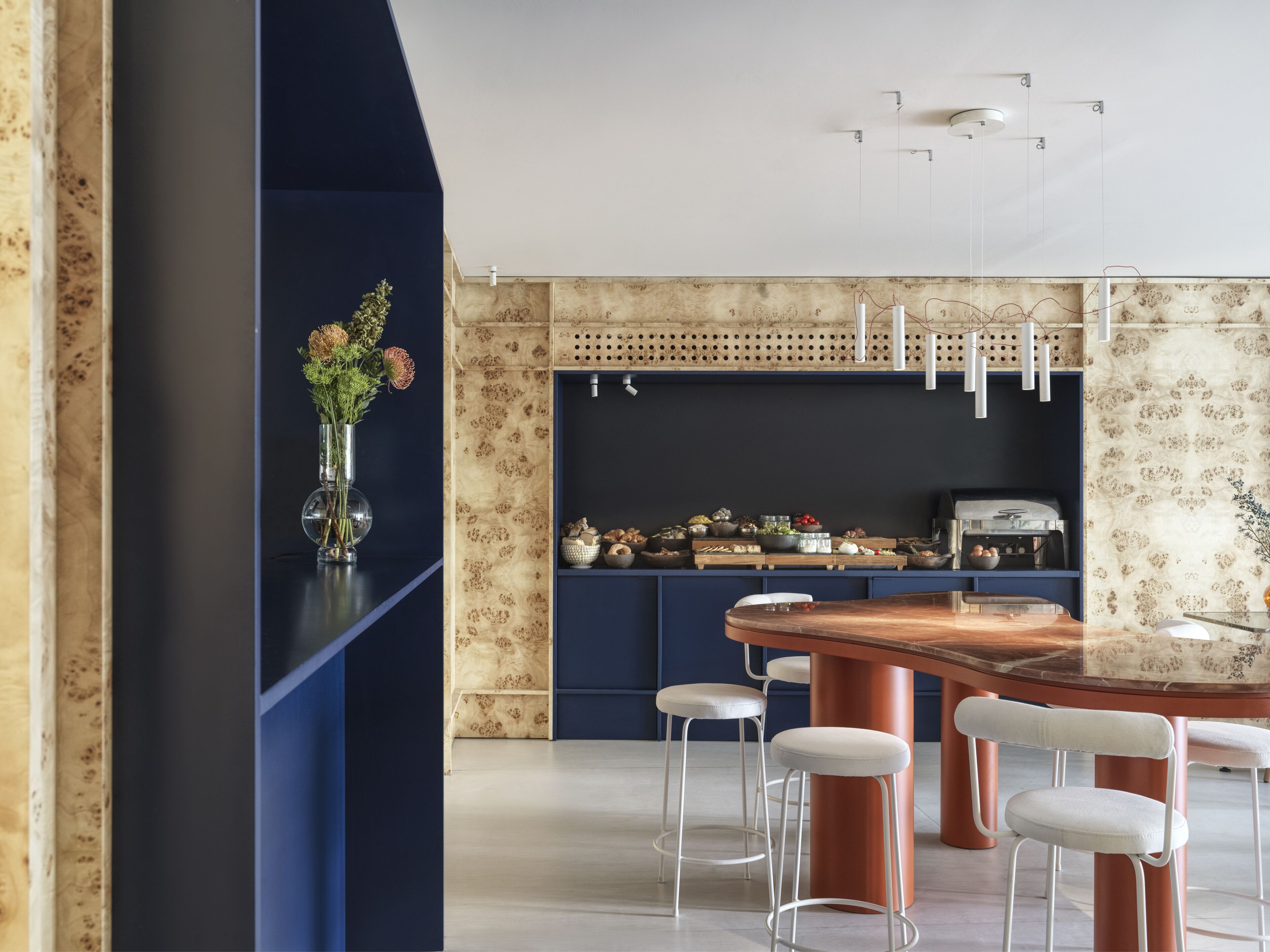 A modern kitchen with a central island, bar stools, and a variety of kitchen appliances.