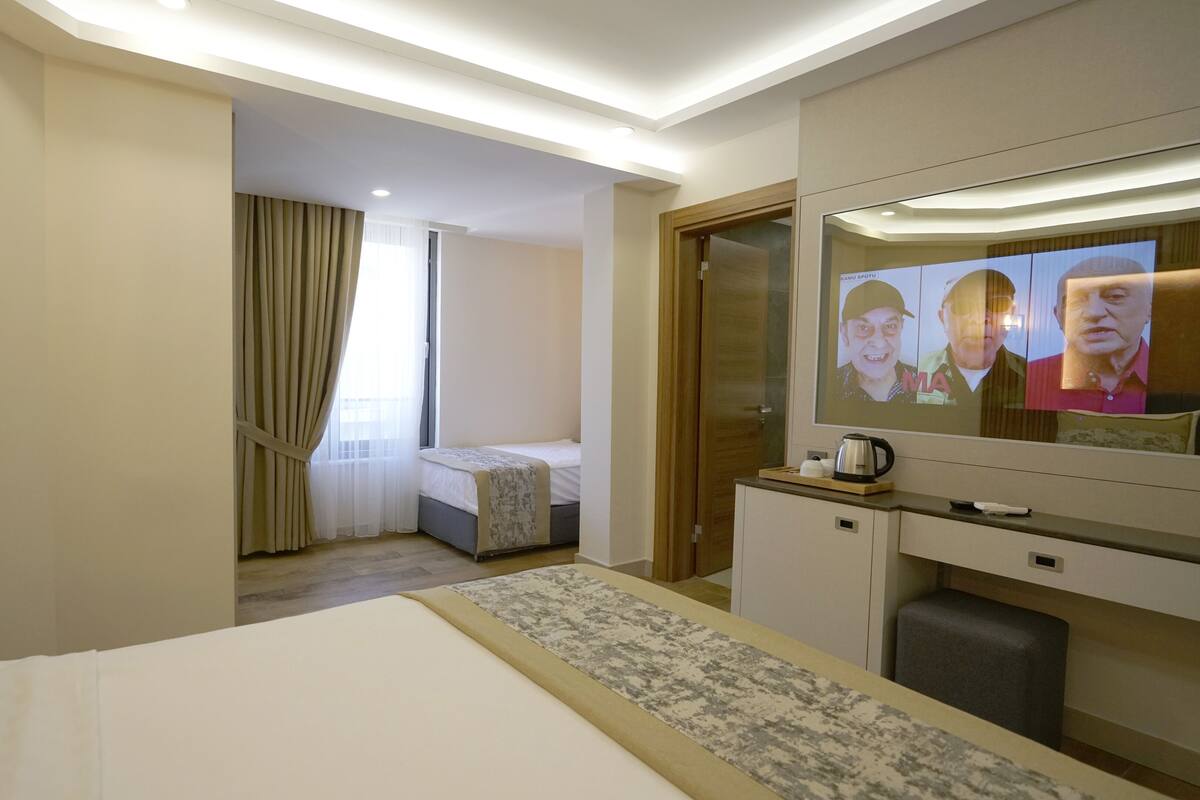 Une chambre d’hôtel comprenant un lit, un bureau avec une télévision et un petit coin salon.