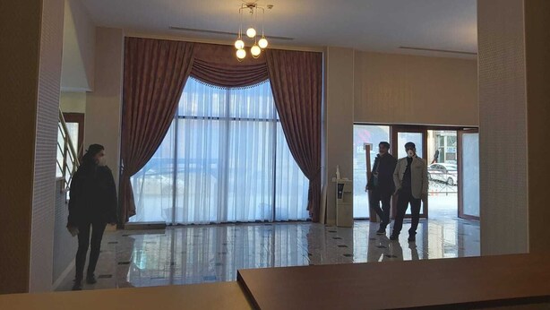 A hotel lobby with a large window, a chandelier, and a staircase. - Baijan Hotel Baku (Baku)