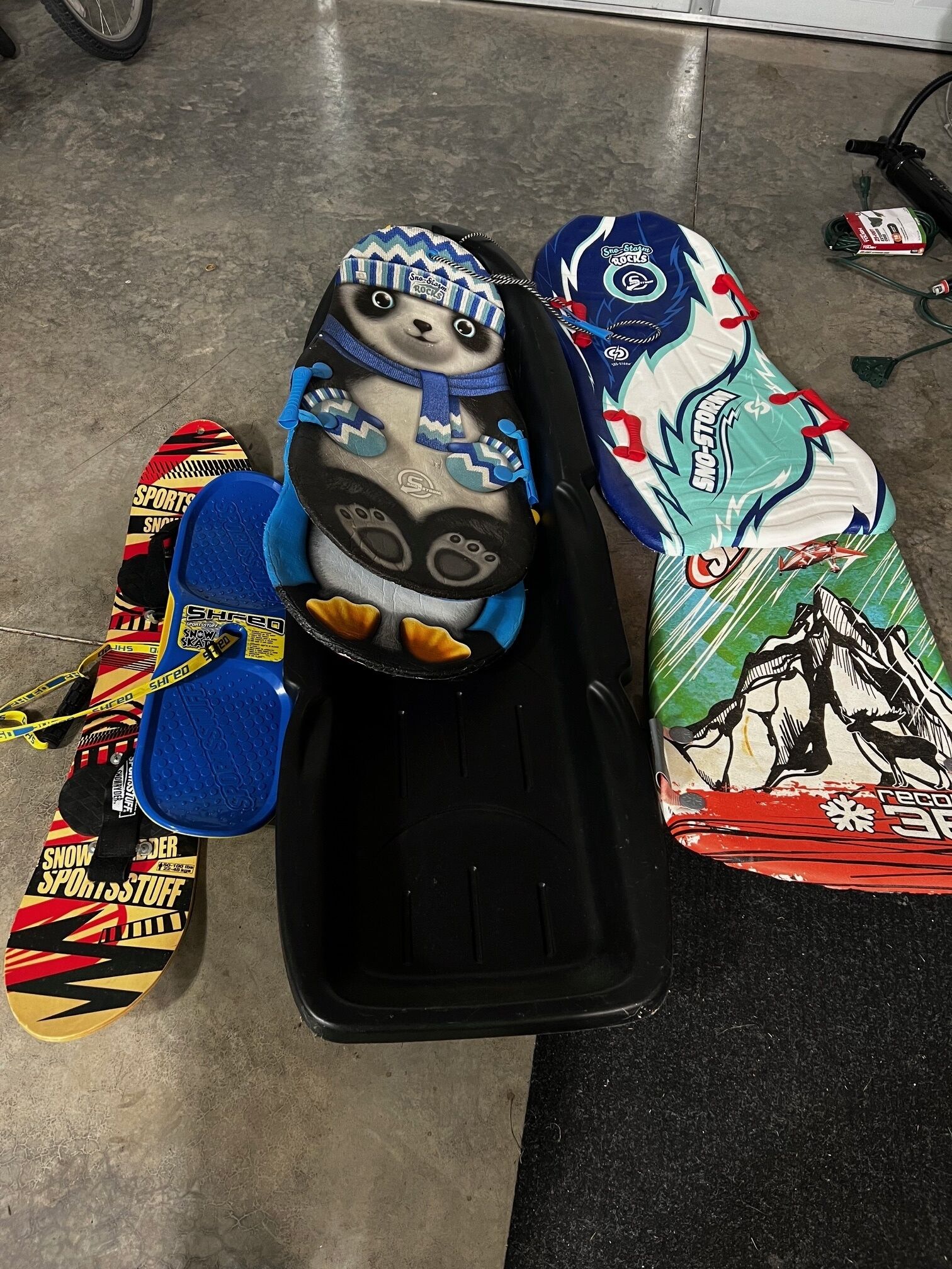 Une planche de snowboard ornée d’un motif d’ours, un casque et une paire de chaussures de snowboard.