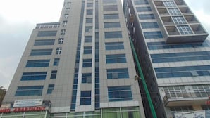 A high-rise building with multiple floors, large windows, and a sign indicating it is an apartment building. - Dabi Hotel & Apartments (Addis Ababa)