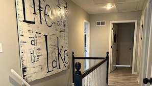 Eine Treppe mit Holzboden und einer Wand mit dem Schriftzug: "Life better at the Lake."