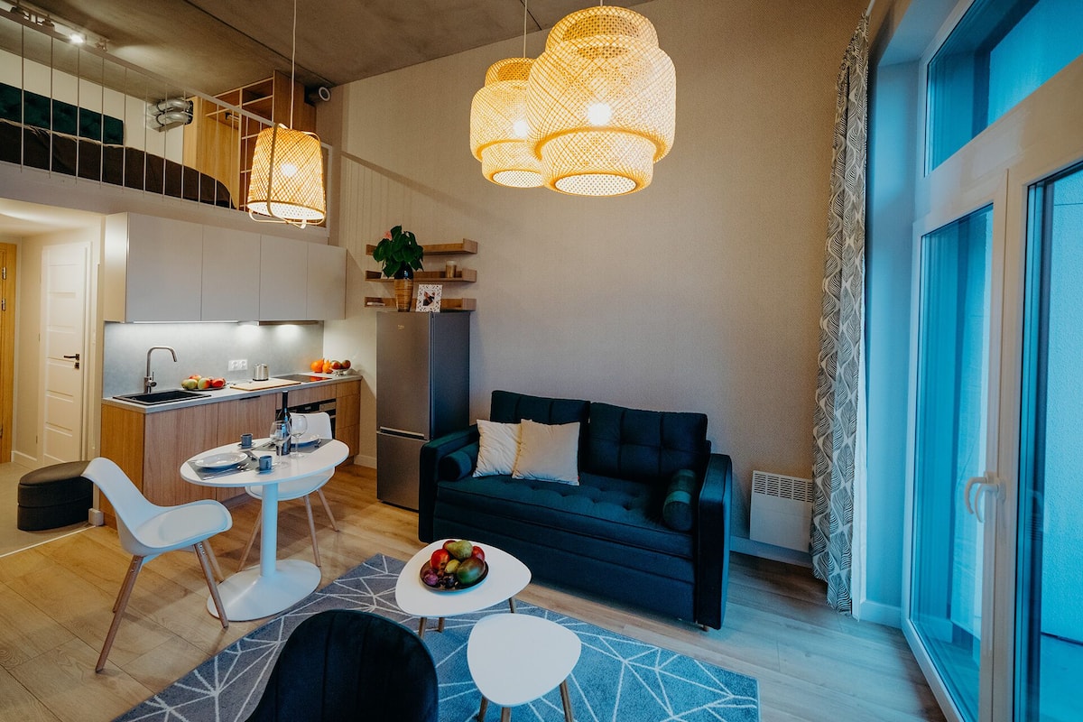A modern living space with a kitchen, dining area, and seating area.