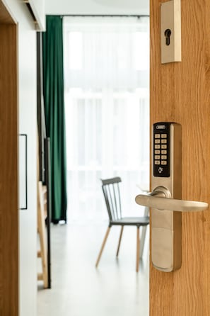 A modern door with a keypad lock and a keyhole. - RentPlanet - Apartamenty Zarembowicza (Wroclaw)