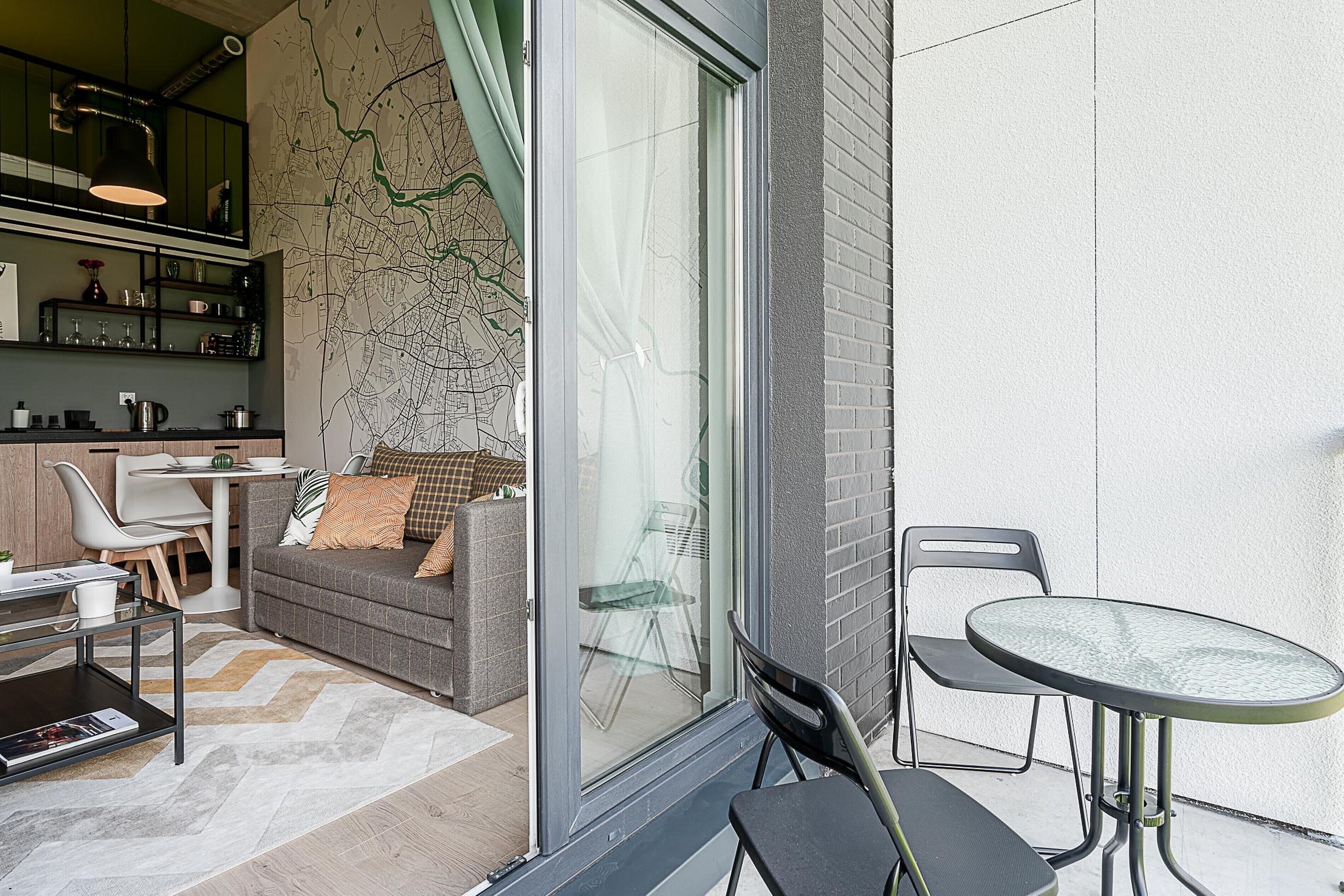 Un espace de vie moderne comprenant un canapé, une table à manger, des chaises et une porte vitrée donnant sur un espace extérieur.