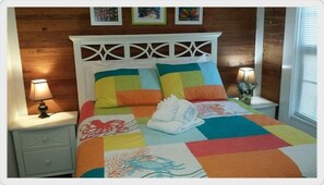Cozy retreat with a vibrant quilt, two nightstands, and a geometric headboard.