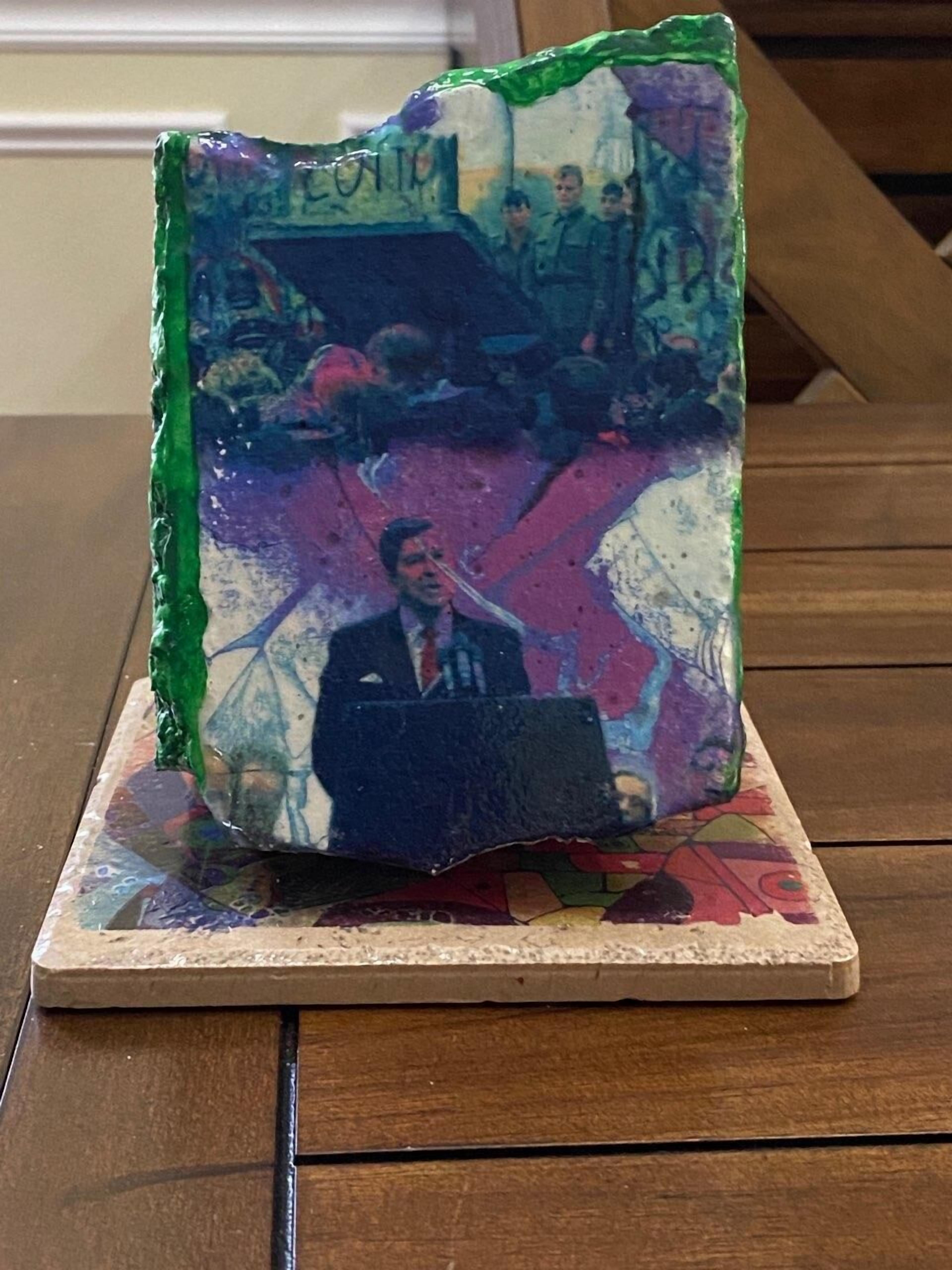 A table with a glass sculpture featuring a man in a suit and tie.