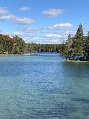 Un lac paisible, bordé d’arbres, sous un ciel dégagé.