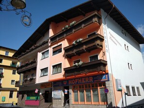 A multi-story building with balconies, a sign for 'Hofherr Apartments Zimmer', and a 'Pension Weirather' sign. - Pension Weirather (Imst)
