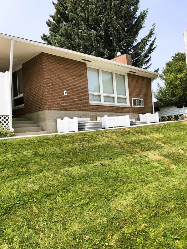 A modern house with a brick exterior, large windows, and a covered porch area.