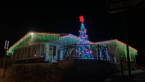 A building with a large Christmas tree decorated with lights and a star on top. - Cozy spacious king bed suite, In the heart of Historic Helena, Montana! (Helena)