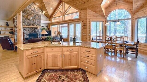 A spacious kitchen with a large island, wooden cabinetry, and a stone accent wall. - Luxury Golf Cabin - Pinetop Lakes - 360 Deck (pinetop)