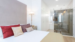 Une chambre à coucher moderne avec un grand lit, une lampe de chevet et un dressing.