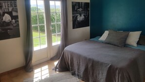 Un dormitorio con cama, una ventana con cortinas y dos carteles en la pared.