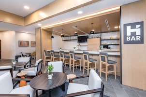 Zona de bar moderna con asientos y una barra.