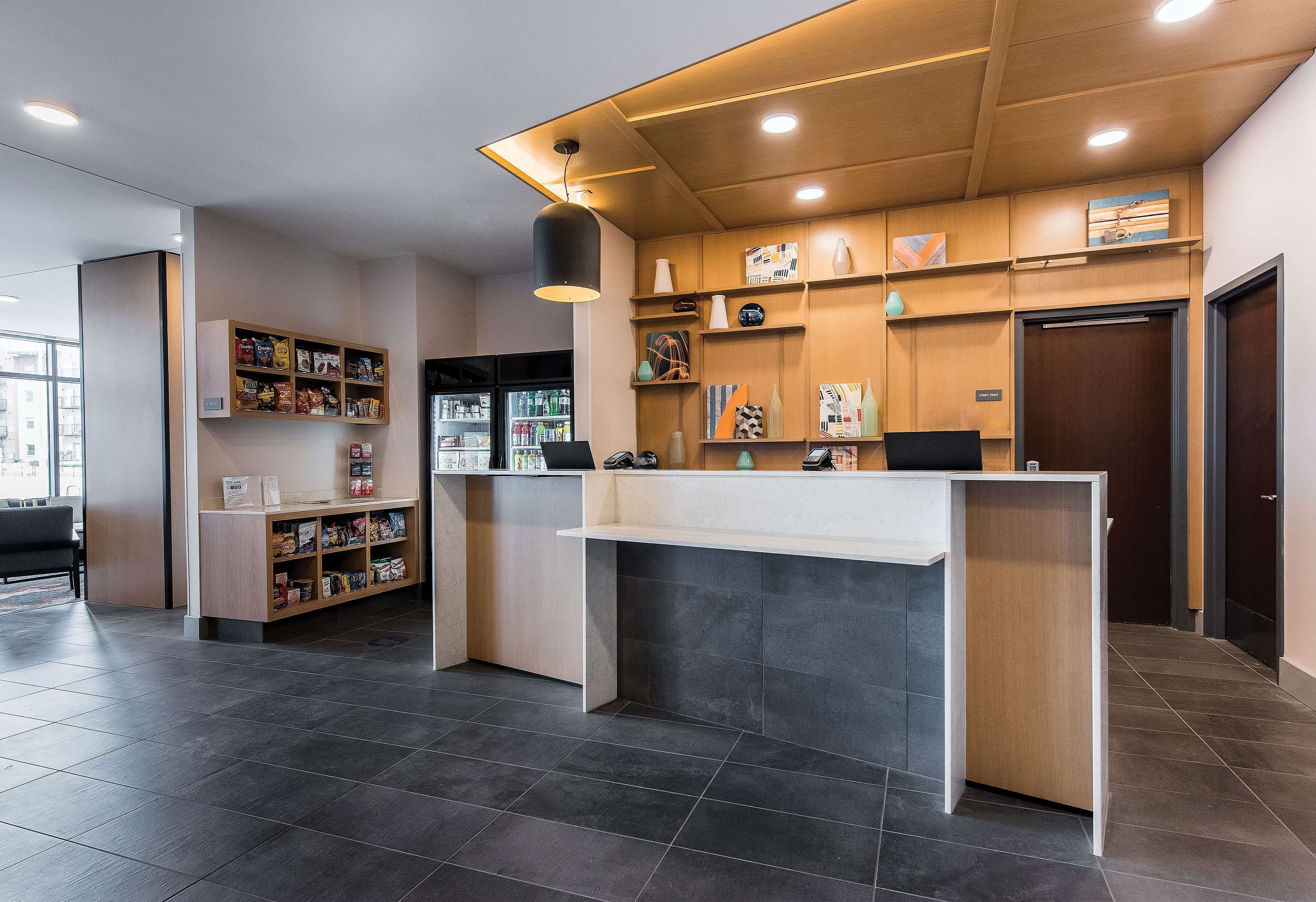 A reception area with a counter, shelves with various items, and a seating area with a chair.