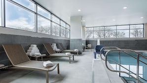Zona de piscina interior moderna amb gandules i una piscina.
