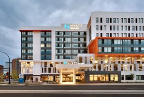 Un moderno hotel Hyatt House con un llamativo letrero de 'Hyatt House', varios pisos y un estacionamiento.