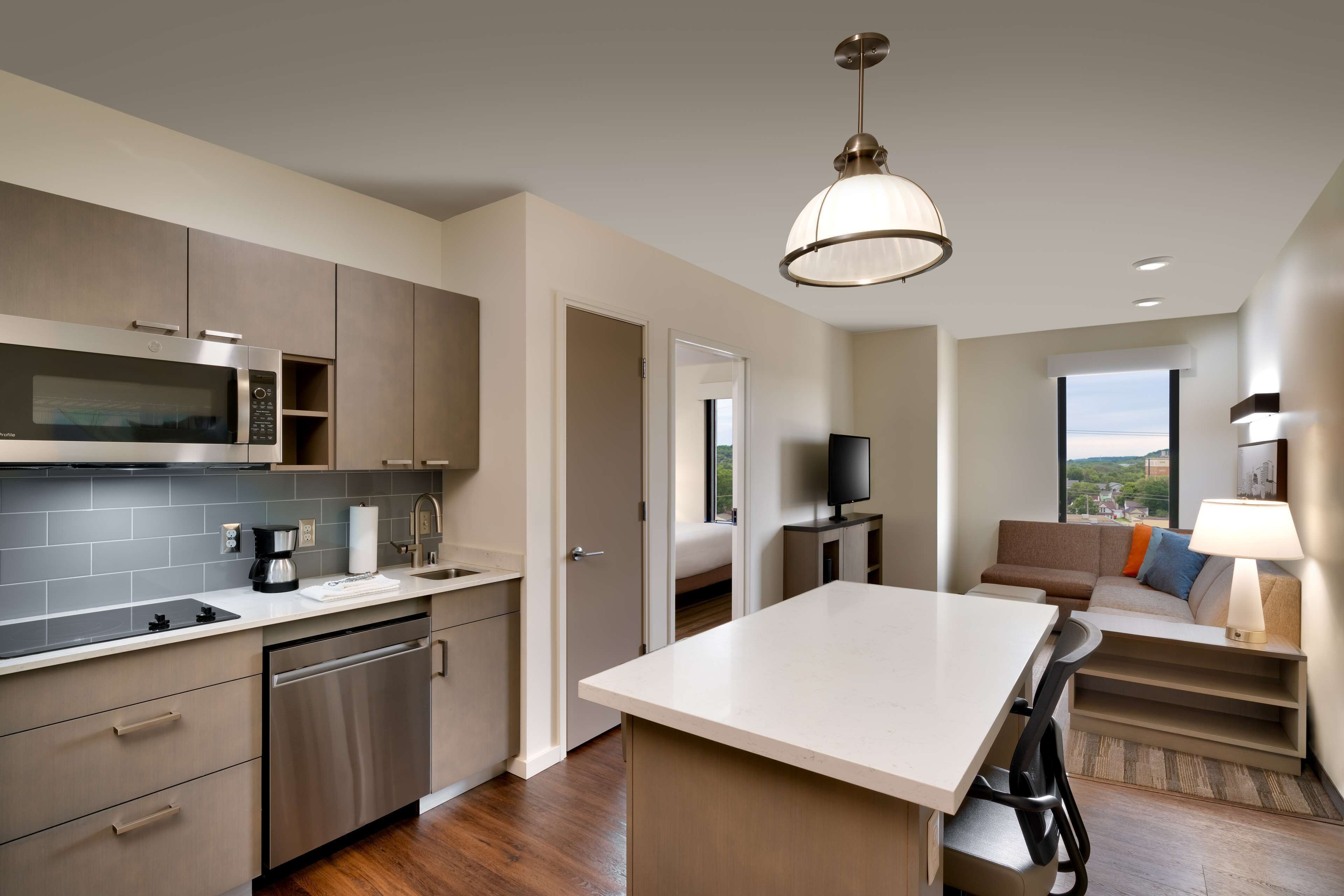 Una cocina moderna con electrodomésticos de acero inoxidable, una zona de comedor con una isla central y un espacio de estar con vistas.