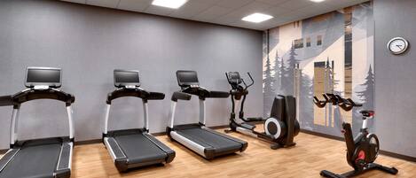 A gym with treadmills, an elliptical, and a stationary bike.