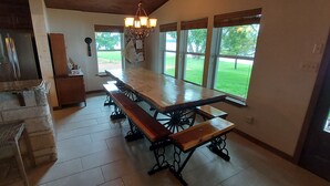 Una cocina amplia con una isla grande, un comedor con varios bancos y ventanas grandes que ofrecen vistas al exterior.
