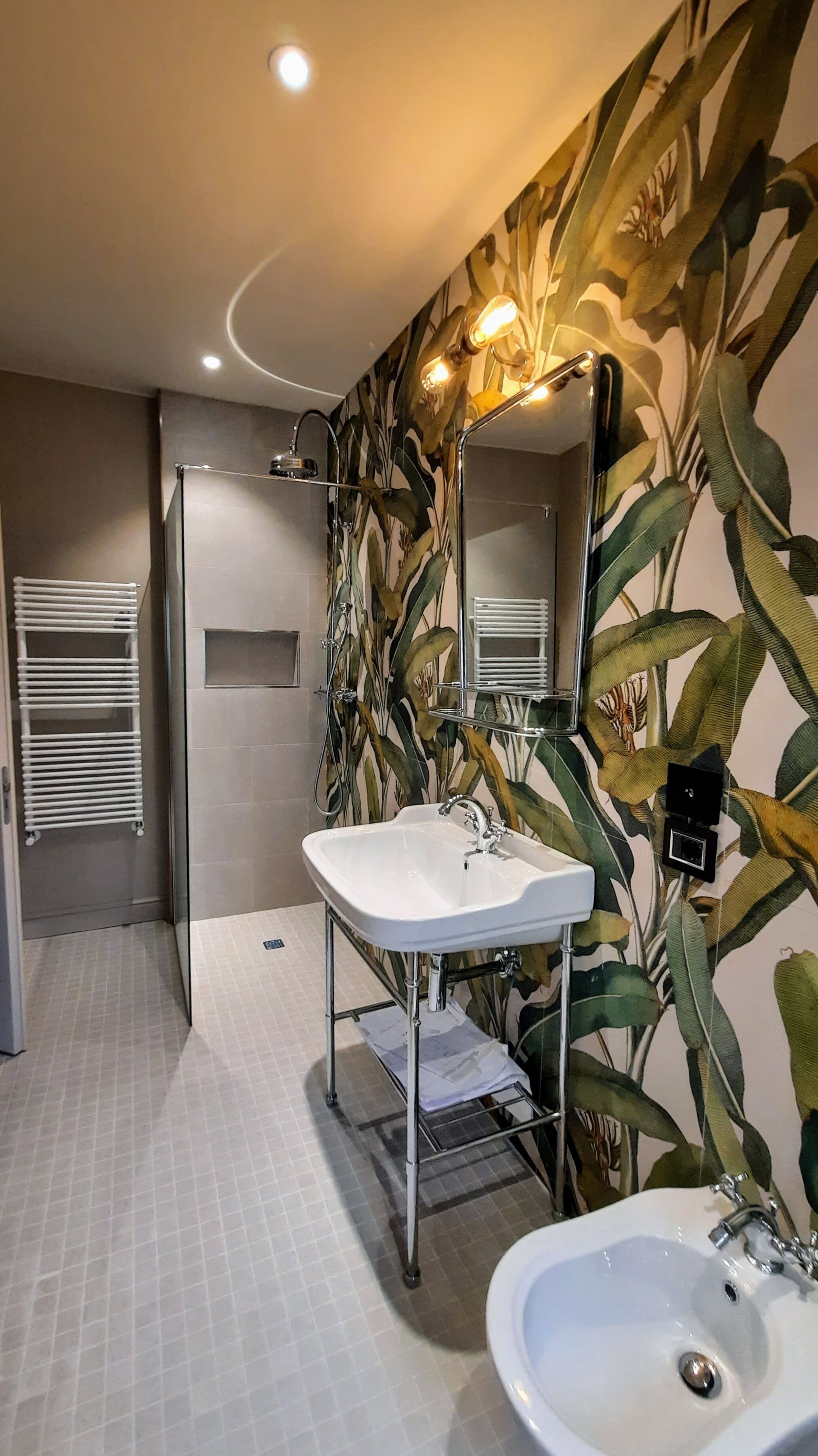 A bathroom with a white sink, a mirror, and a shower.