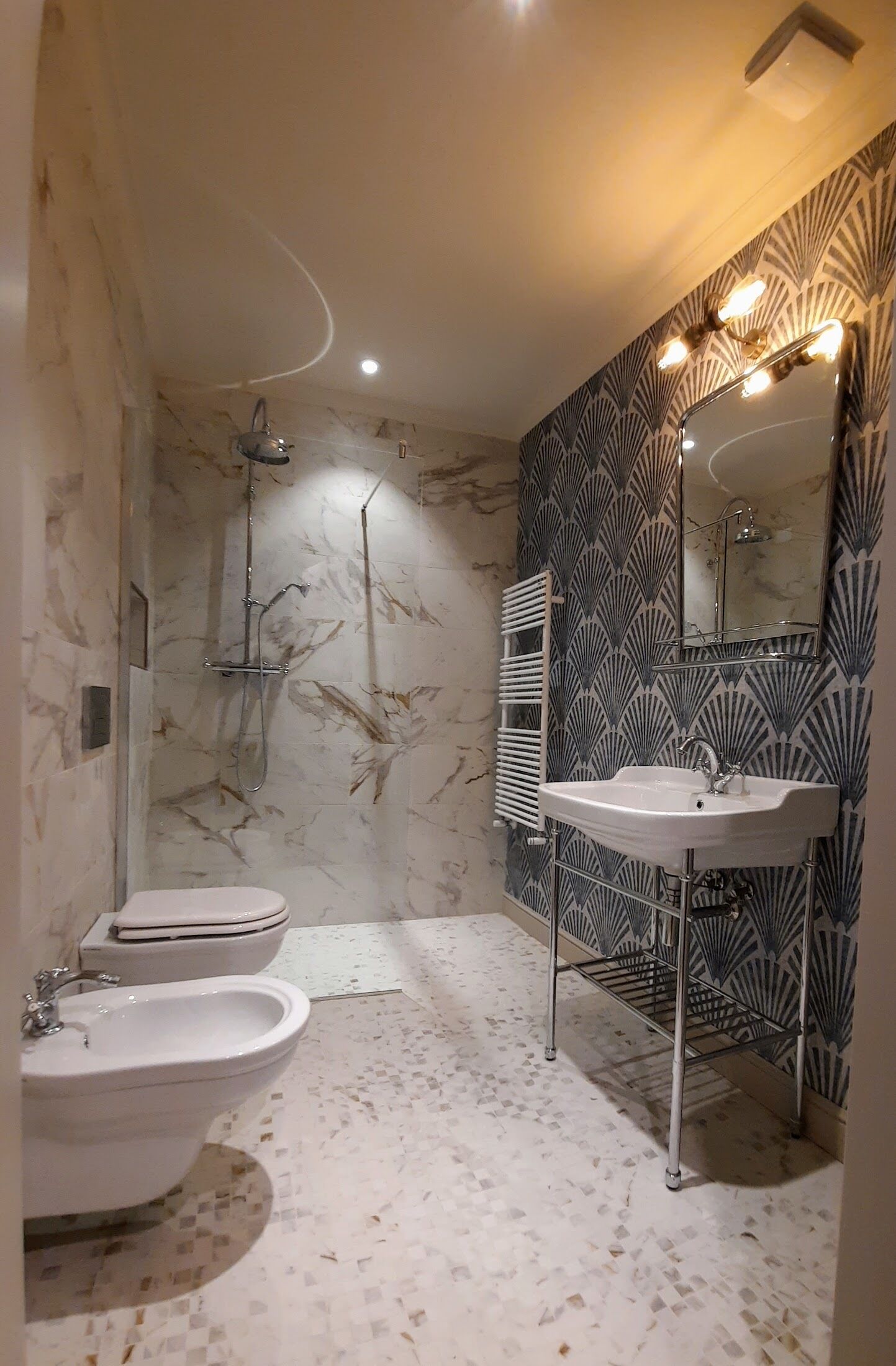 A modern bathroom with a shower, two sinks, and a vanity with a mirror.