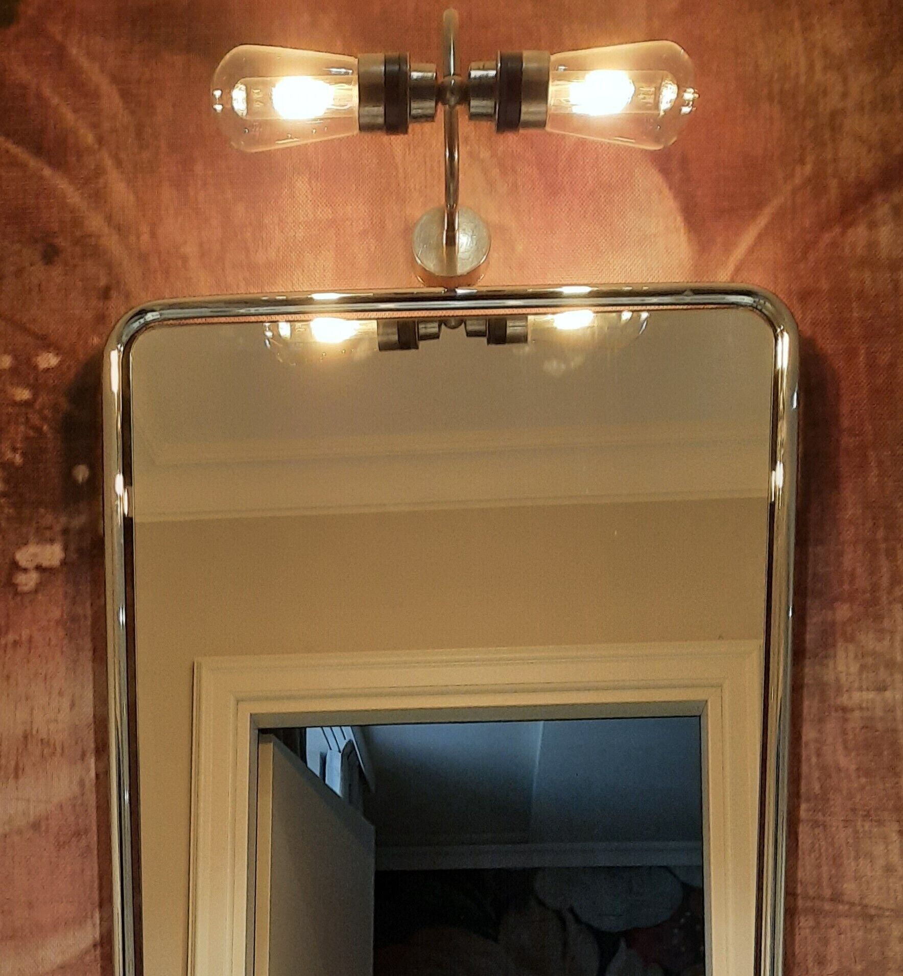A mirror with a light fixture above it.