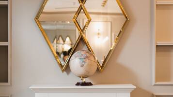 A fireplace with a globe on top, flanked by two diamond-shaped mirrors.