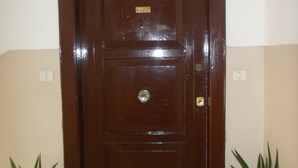 A brown door with a brass plate and a keyhole, flanked by two potted plants. - B&B Maddalena di San Zeno (Verona)
