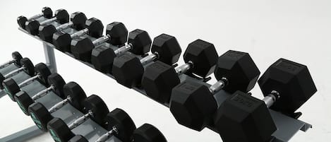 Un juego de mancuernas negras sobre un soporte.