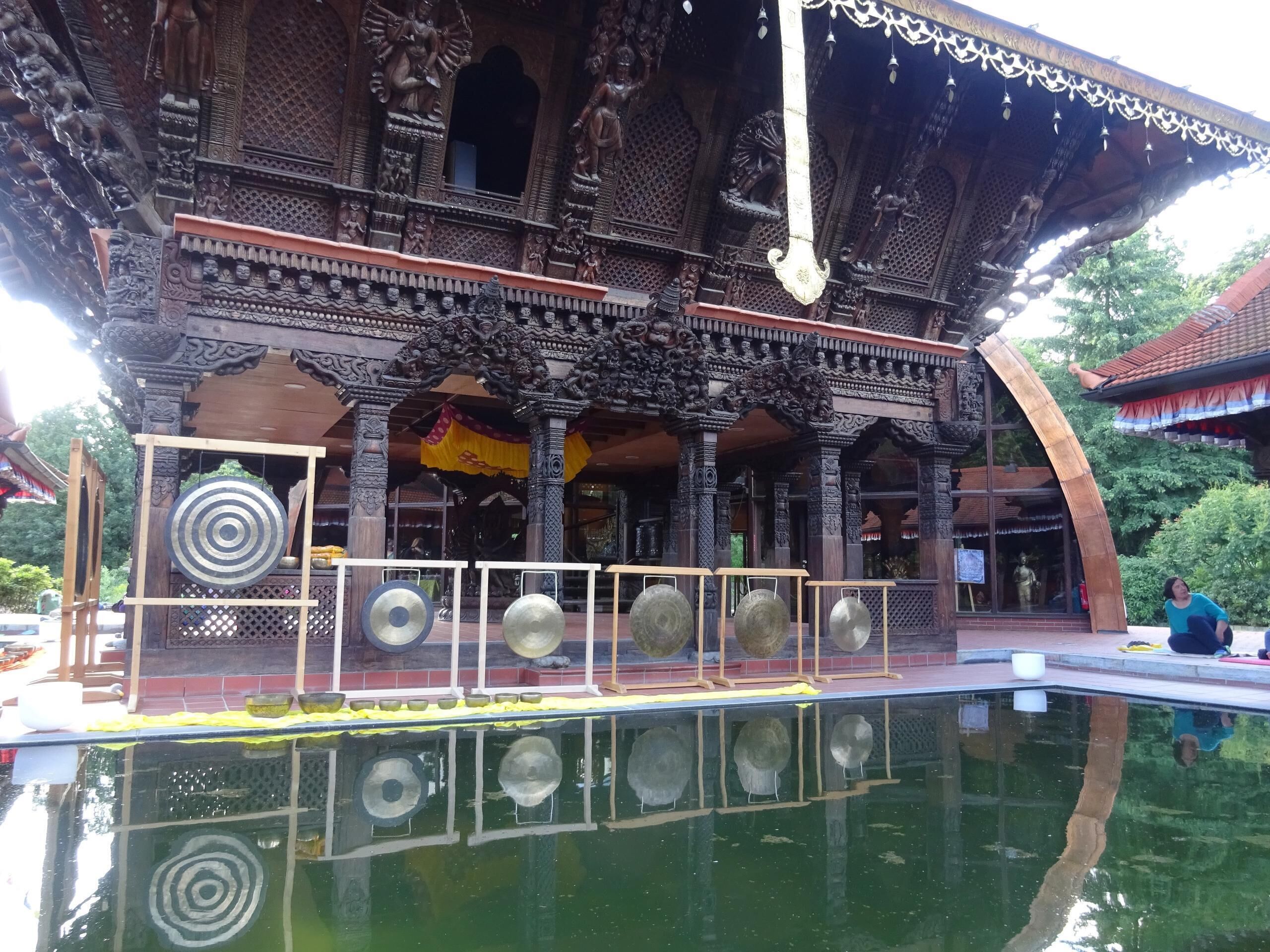 A traditional building with intricate carvings and a reflection in the water.